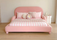 Pink bed dressed with stripes