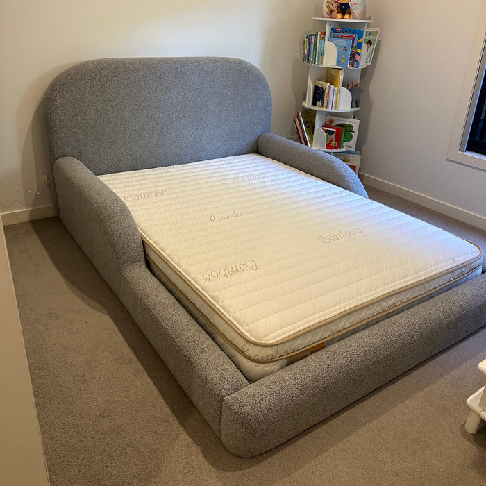 Gray Bed with a Eco Kids mattress on it in a room setting.
