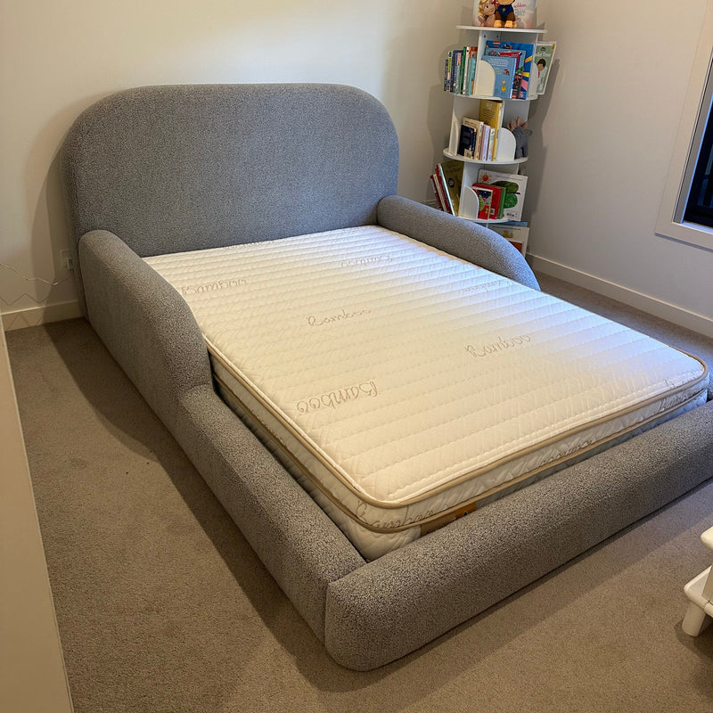 Gray Bed with a Eco Kids mattress on it in a room setting.