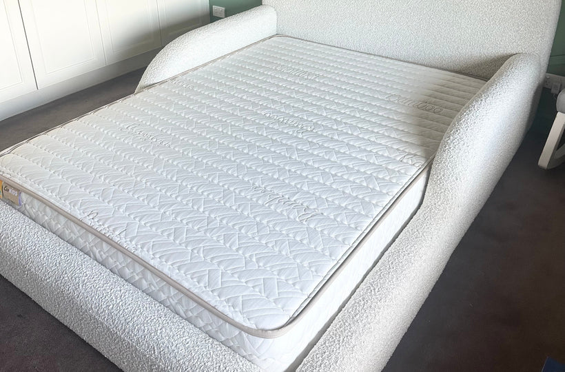 White upholstered bed in a room with geometric wall design