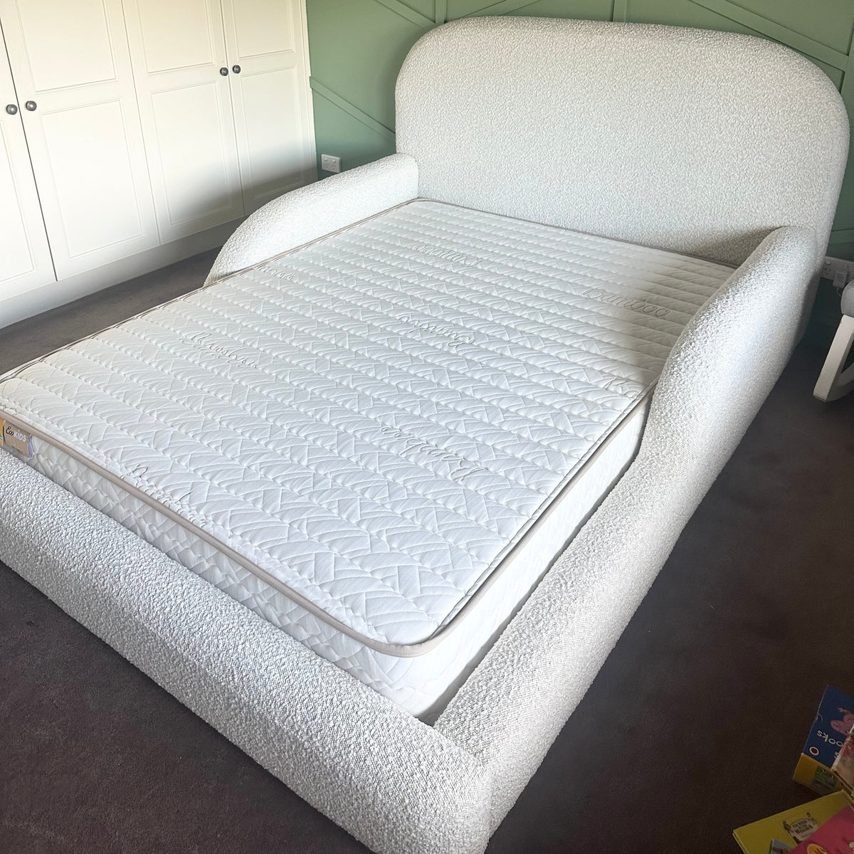 White upholstered bed in a room with geometric wall design
