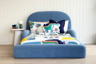 Tulum Kids Bed in soft blue upholstery with rounded padded frame by Kamari